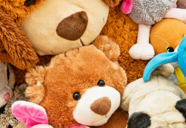 Many Soft plush fluffy toys sits on the floor in the children's room