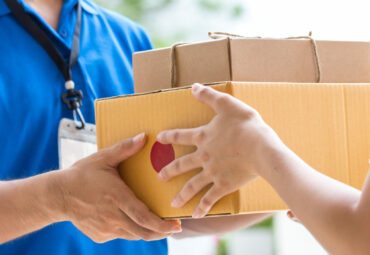 Woman hand accepting a delivery of boxes from deliveryman