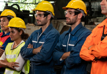 Skillful worker stand together showing teamwork in the factory . Industrial people and manufacturing labor concept .