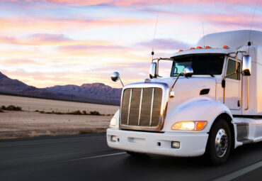 Truck and highway at sunset - transportation background