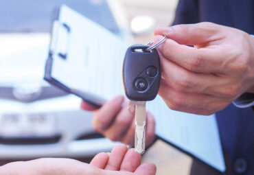 The car salesman and the key to the new owner.