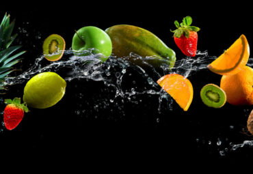 Fruits on black background with water splash