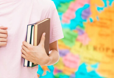 student hand with books and map, learn languages