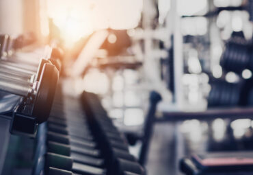 gym interior background of dumbbells on barbell in fitness and workout room