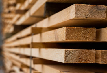 Piles of wooden boards in the sawmill, planking. Warehouse for sawing boards on a sawmill outdoors. Wood timber stack of wooden blanks construction material. Industry