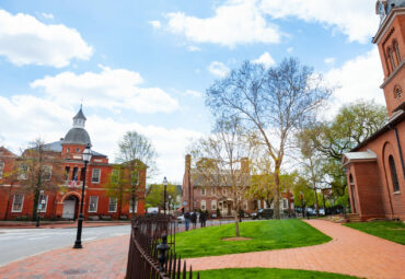 Government House and St. Anne's Parish Episcopal church in Annapolis MA with old tree branches at spring, Maryland USA