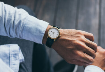 man fashionable wearing stylish looking at luxury watch on hand check the time at workplace.concept for managing time organization working,punctuality,appointment