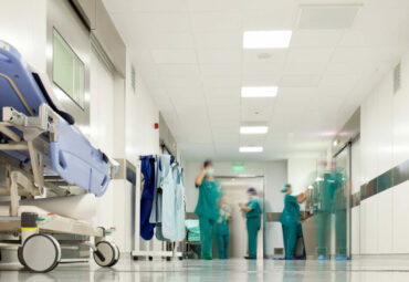 Blurred figures of people with medical uniforms in hospital corridor