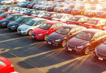 Dealer New Cars Stock. Colorful Brand New Compact Vehicles For Sale Awaiting on the Dealer Parking Lot. Car Market Business Concept.