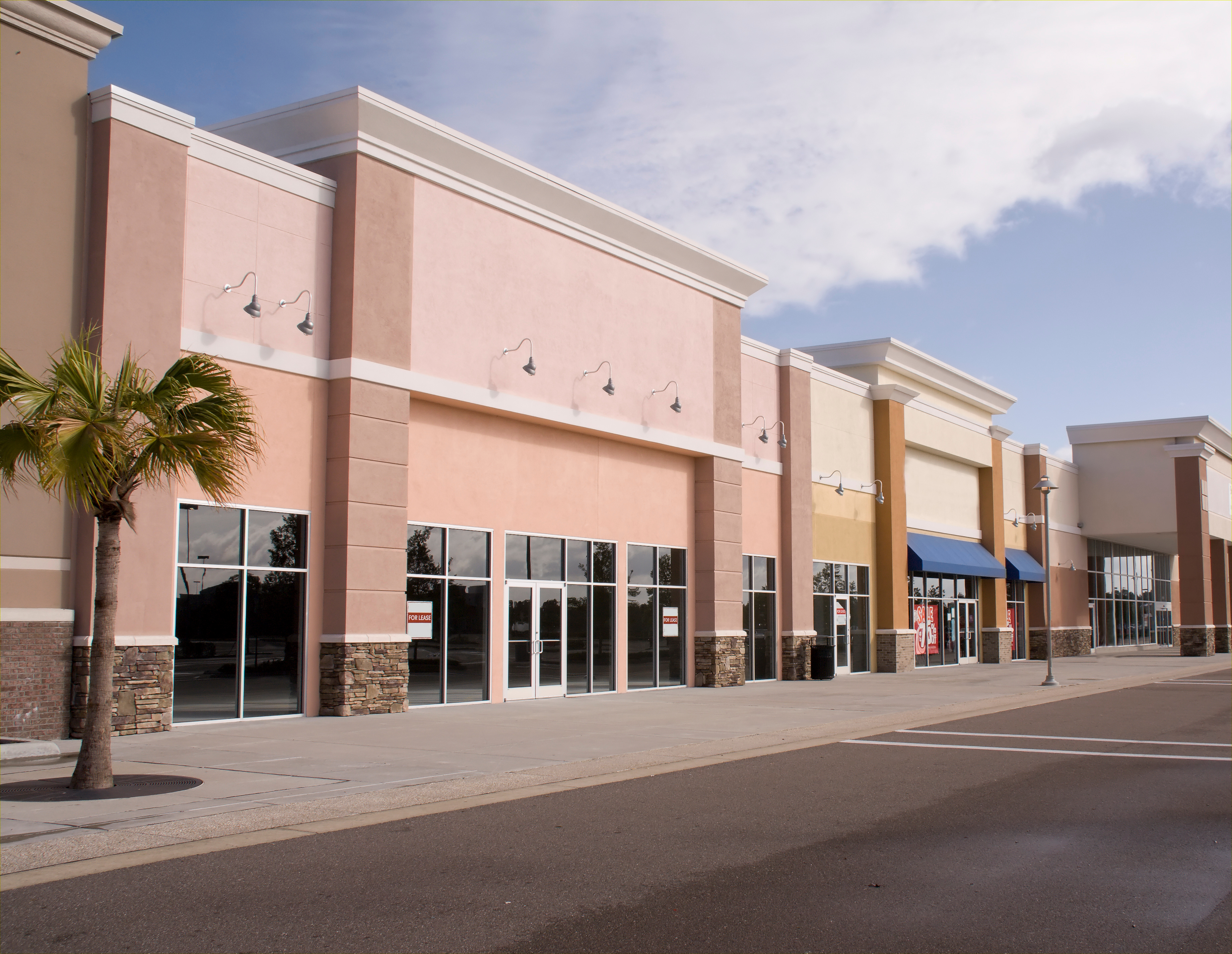 empty strip mall with pastel stucco and stone accents